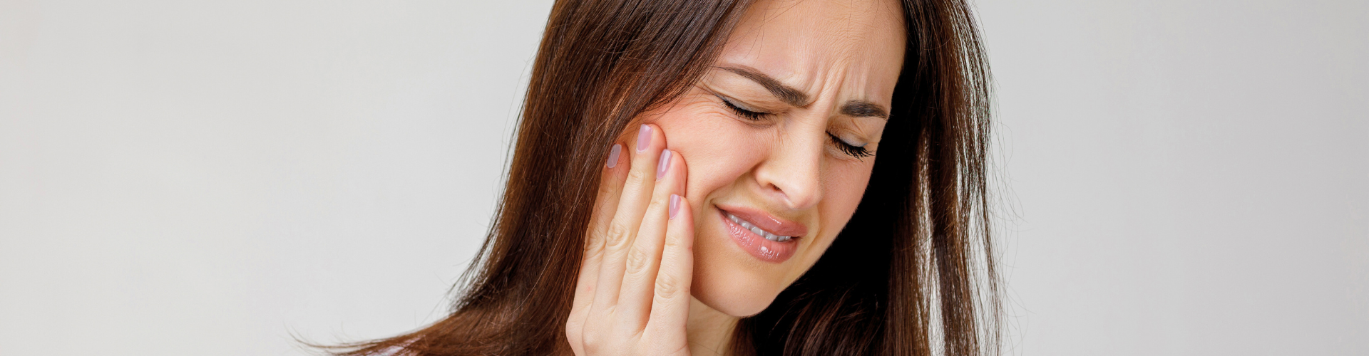 Woman holding her cheek in pain.